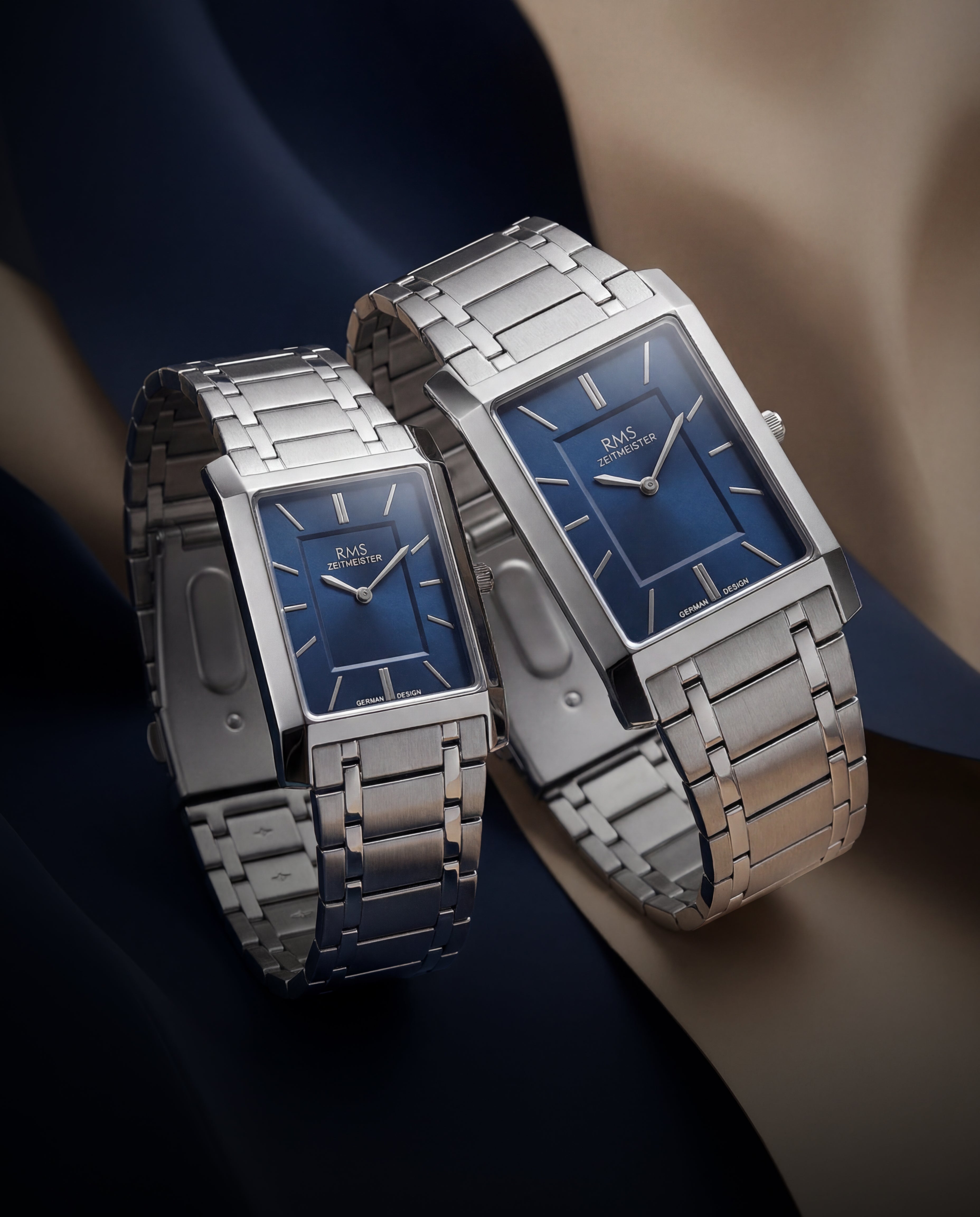 Two matching RMS Zeitmeister rectangular blue dial watches with steel bracelets, a his-and-hers watch gift set